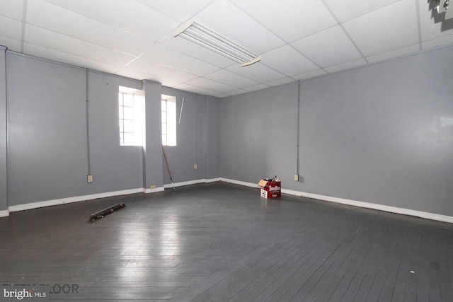 basement featuring a paneled ceiling and hardwood / wood-style floors