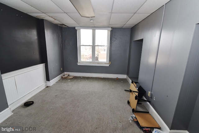 carpeted empty room with a drop ceiling