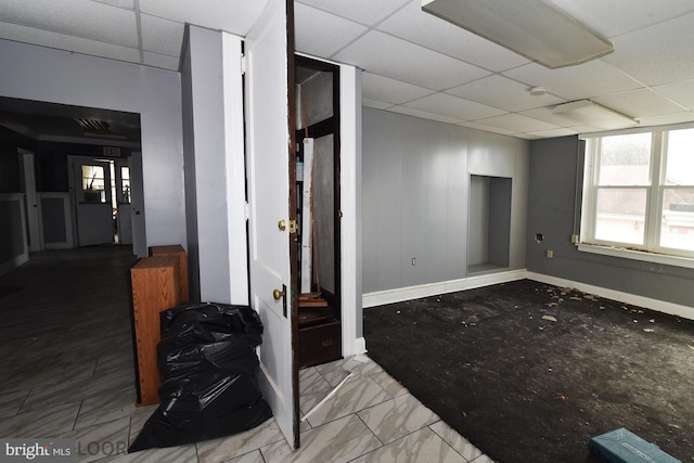 interior space featuring tile patterned floors, a paneled ceiling, and plenty of natural light