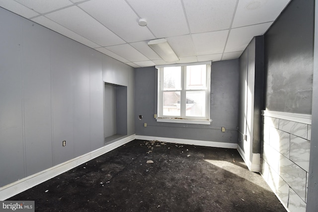 empty room featuring a paneled ceiling