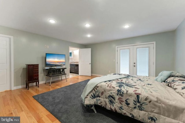 bedroom with french doors, connected bathroom, and light hardwood / wood-style floors