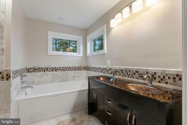 bathroom with double vanity, a bathing tub, and backsplash