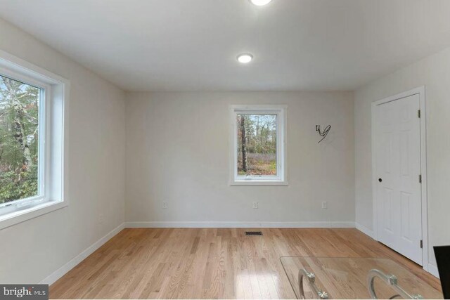 unfurnished room with light wood-type flooring and plenty of natural light