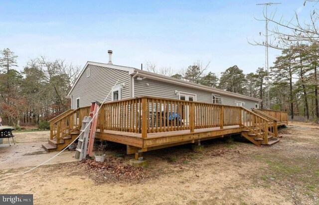 rear view of property featuring a wooden deck