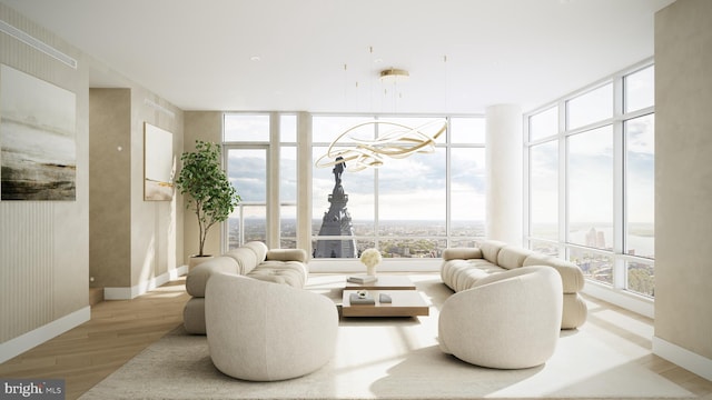 interior space featuring a notable chandelier, light wood-type flooring, and floor to ceiling windows