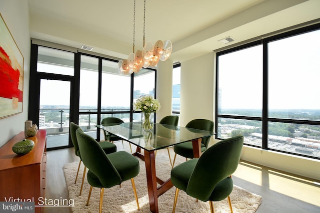 dining space featuring an inviting chandelier, a wealth of natural light, and light hardwood / wood-style floors