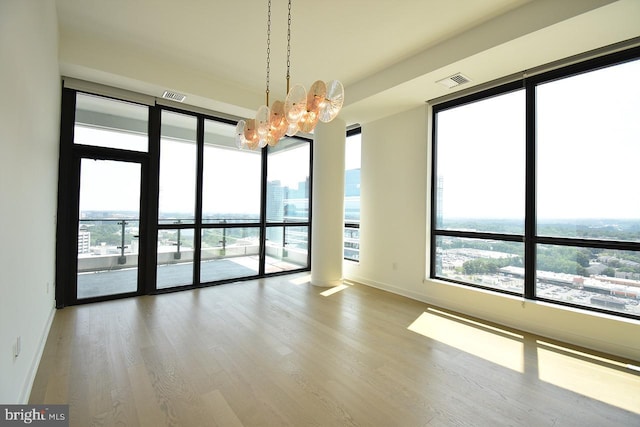 unfurnished room with hardwood / wood-style floors and a healthy amount of sunlight