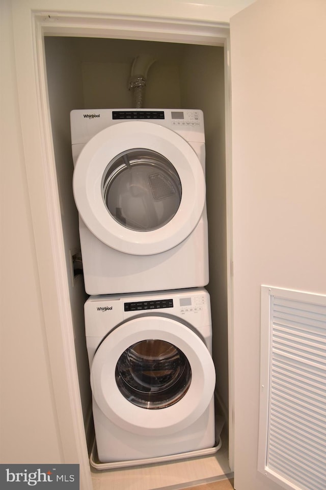 clothes washing area featuring stacked washer / drying machine