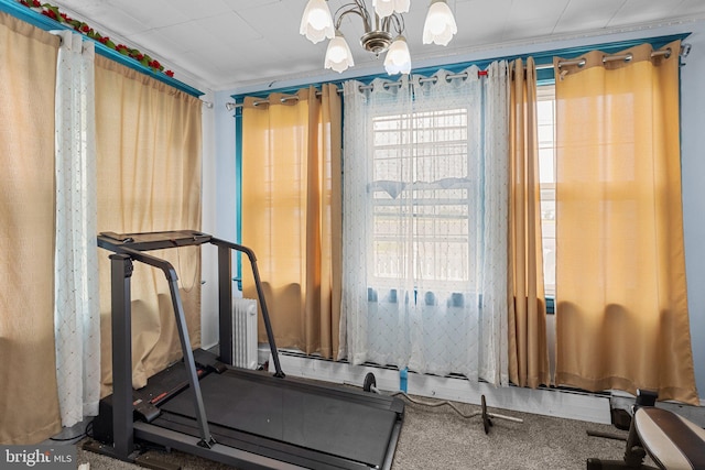 workout area featuring crown molding, radiator heating unit, and an inviting chandelier