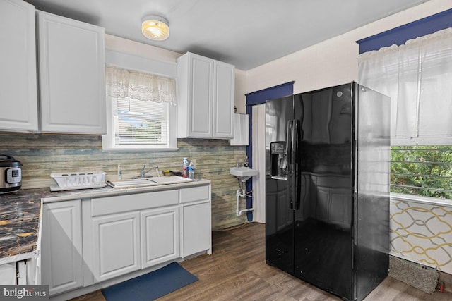 kitchen featuring sink, dark hardwood / wood-style flooring, black refrigerator with ice dispenser, and white cabinets