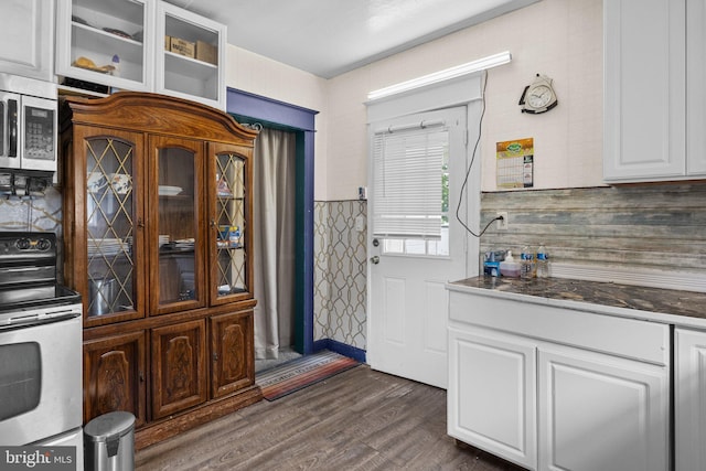 kitchen with dark hardwood / wood-style flooring, white cabinets, and appliances with stainless steel finishes