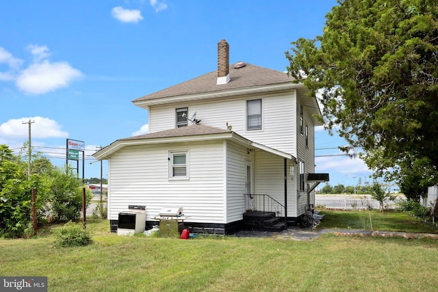 rear view of house featuring a yard