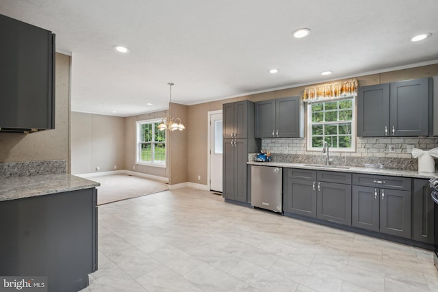 kitchen featuring dishwasher, a sink, light stone countertops, a chandelier, and backsplash