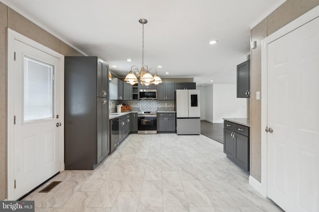 kitchen featuring gray cabinets, hanging light fixtures, backsplash, an inviting chandelier, and appliances with stainless steel finishes