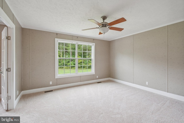 spare room with a textured ceiling, ceiling fan, carpet flooring, and visible vents