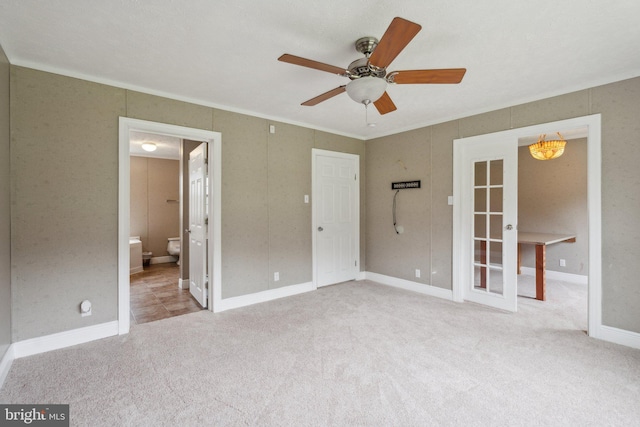 unfurnished bedroom with carpet floors, ensuite bath, baseboards, and crown molding