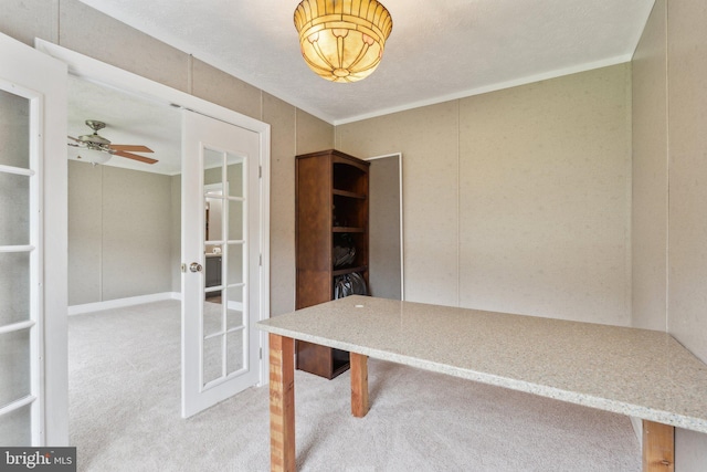 unfurnished office featuring a ceiling fan, french doors, and light colored carpet