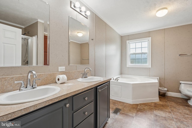 full bathroom featuring a sink, a textured ceiling, toilet, and a bath