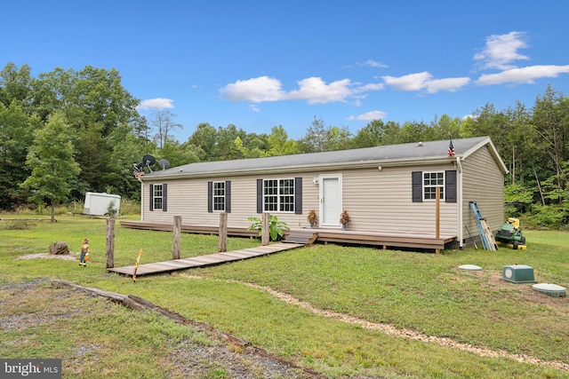 manufactured / mobile home featuring a front lawn and a wooden deck