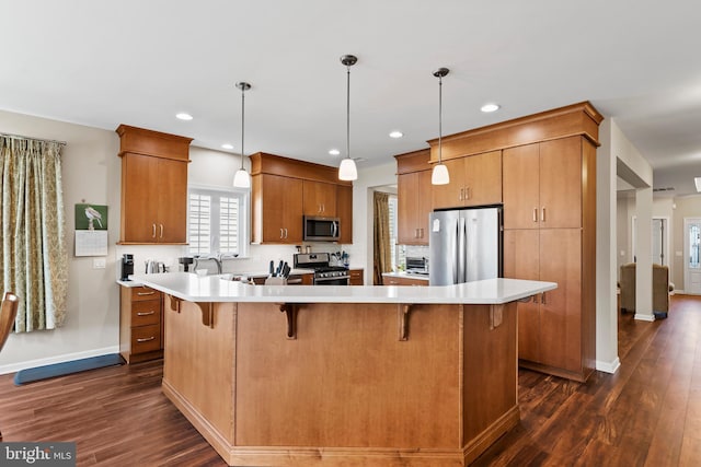 kitchen featuring stainless steel appliances, hanging light fixtures, and a spacious island