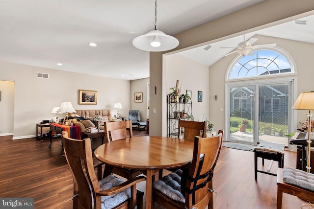 dining room featuring ceiling fan, lofted ceiling, a wealth of natural light, and dark hardwood / wood-style flooring