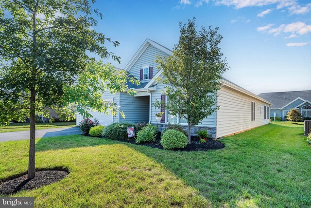 obstructed view of property featuring central air condition unit and a front yard