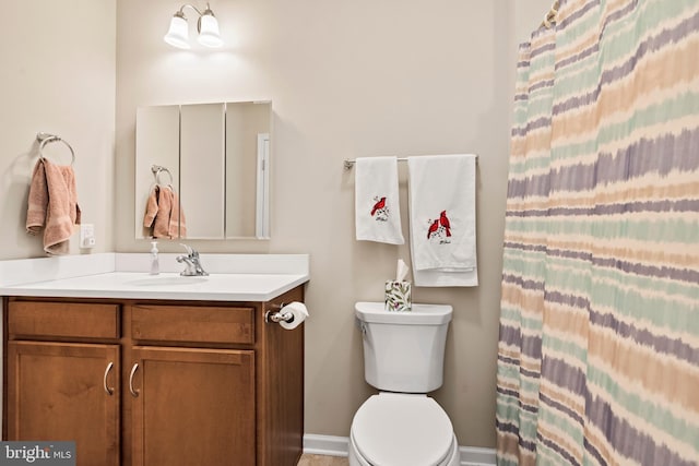 bathroom featuring vanity, curtained shower, and toilet