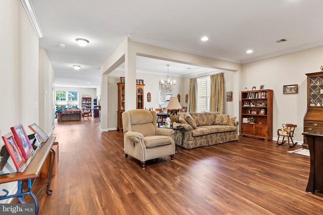 living room featuring an inviting chandelier, dark wood-type flooring, and ornamental molding