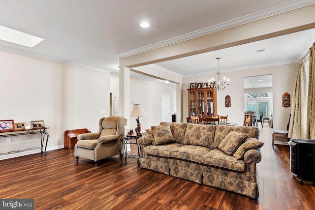 living room with an inviting chandelier, a skylight, ornamental molding, and dark hardwood / wood-style floors