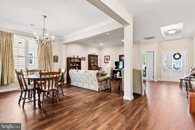 dining area with crown molding, dark hardwood / wood-style floors, and a chandelier