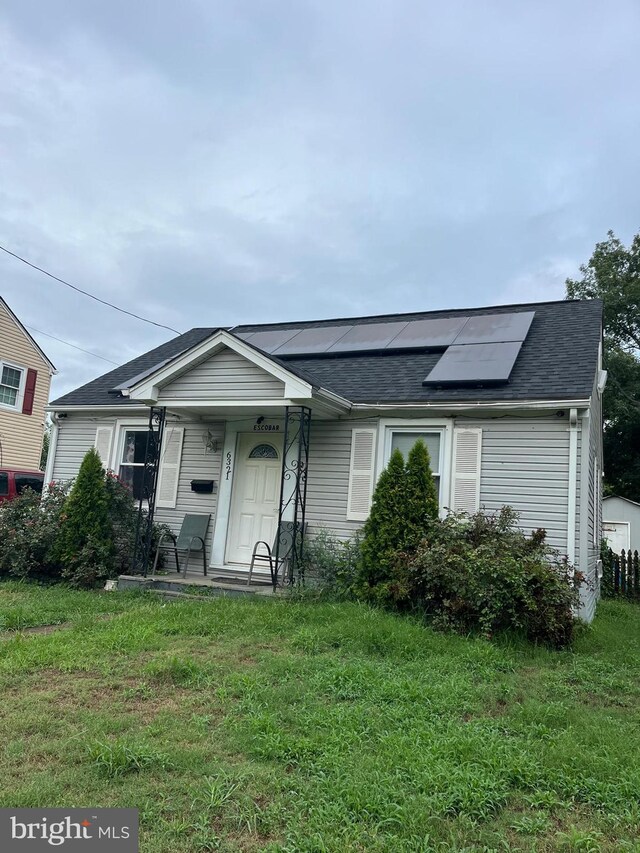 ranch-style house with solar panels and a front yard