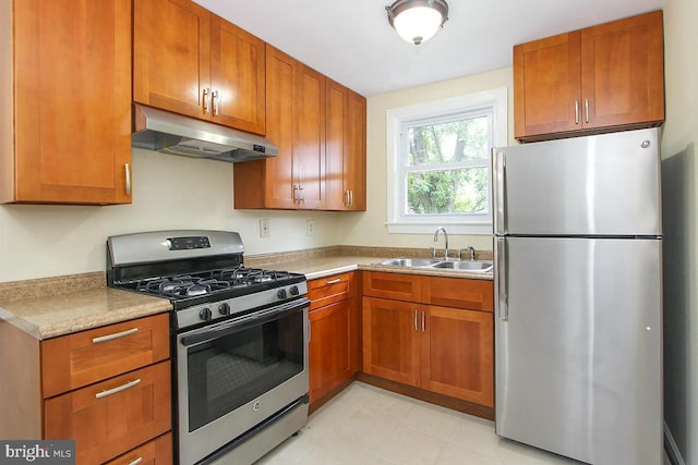 kitchen with light tile patterned floors, sink, stainless steel appliances, and light stone countertops