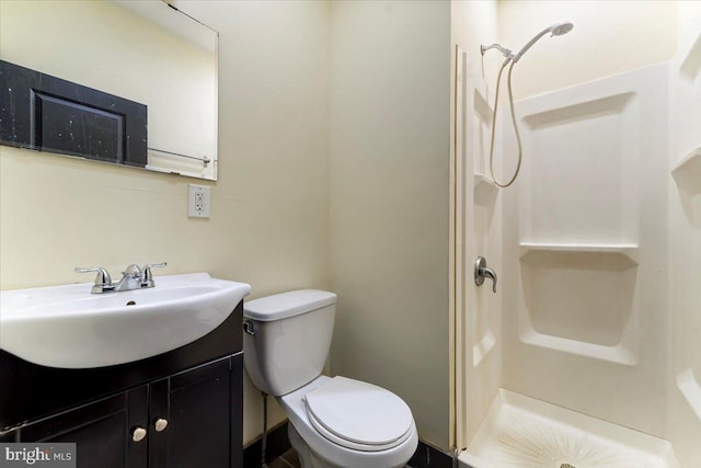 bathroom featuring walk in shower, vanity, tile patterned flooring, and toilet