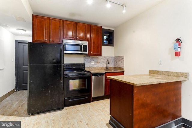 kitchen featuring black appliances, backsplash, sink, and light hardwood / wood-style flooring