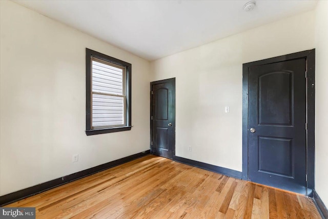 unfurnished room with light wood-type flooring