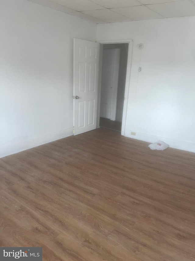 unfurnished room with hardwood / wood-style floors and a paneled ceiling