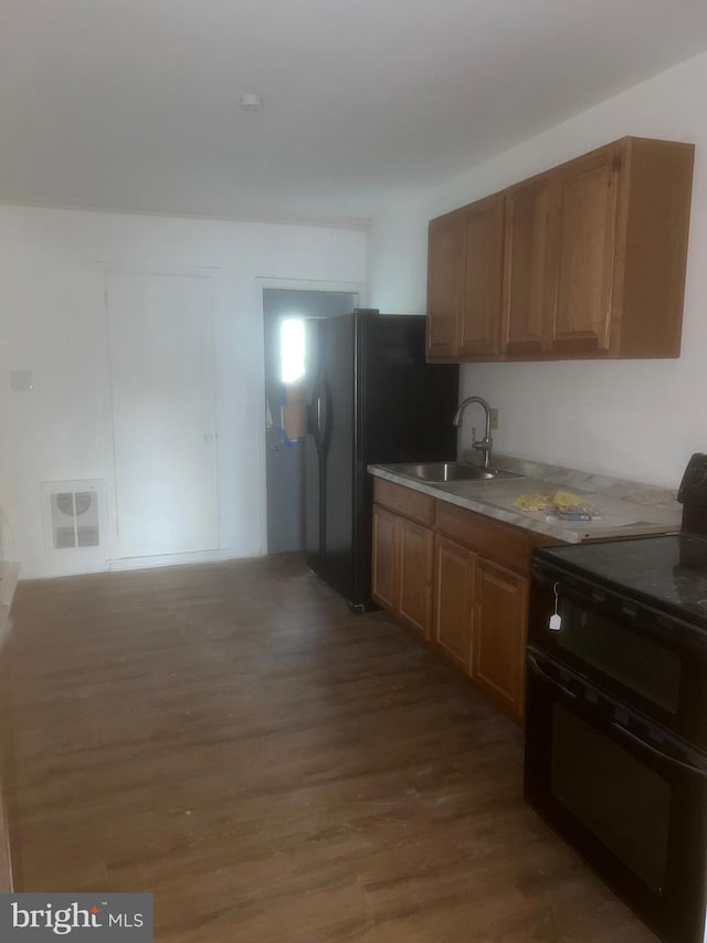 kitchen featuring sink, black range, and hardwood / wood-style floors