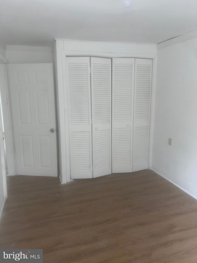 unfurnished bedroom with hardwood / wood-style floors and a closet