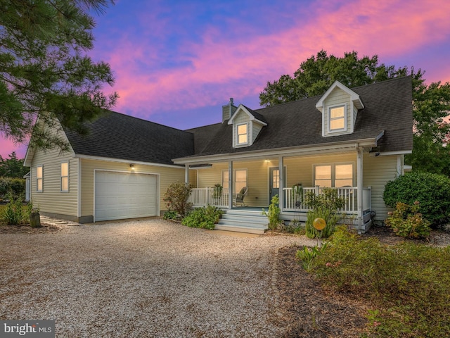 new england style home featuring a garage and a porch