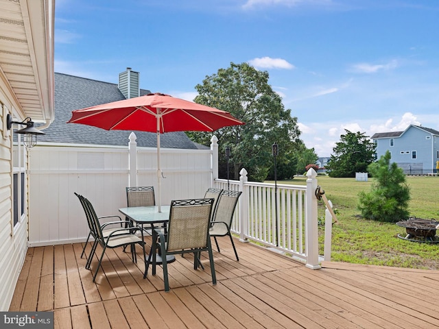 deck with an outdoor fire pit and a yard