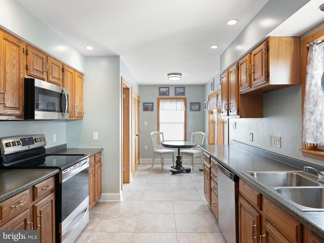 kitchen with appliances with stainless steel finishes, light tile patterned floors, and sink