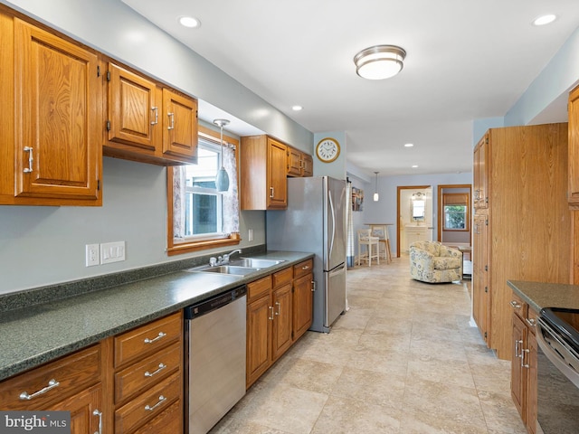 kitchen with appliances with stainless steel finishes, light tile patterned flooring, sink, and a wealth of natural light