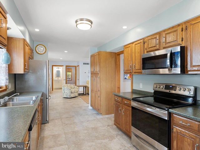 kitchen featuring appliances with stainless steel finishes, light tile patterned floors, and sink