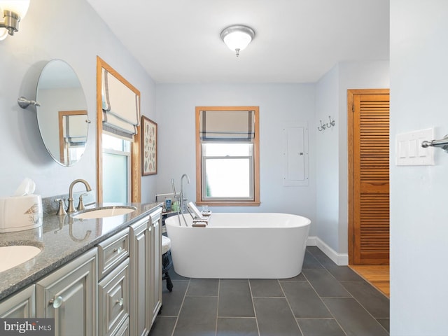 bathroom with double sink vanity, a washtub, plenty of natural light, and tile patterned floors