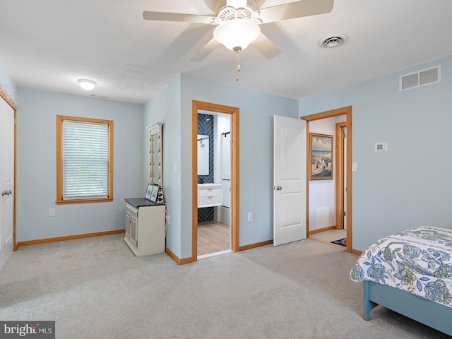 bedroom with ensuite bath, light colored carpet, and ceiling fan