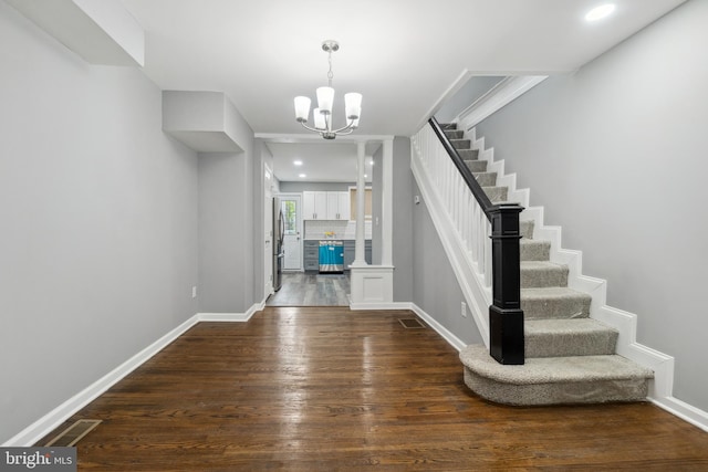 foyer entrance featuring a chandelier and dark hardwood / wood-style floors