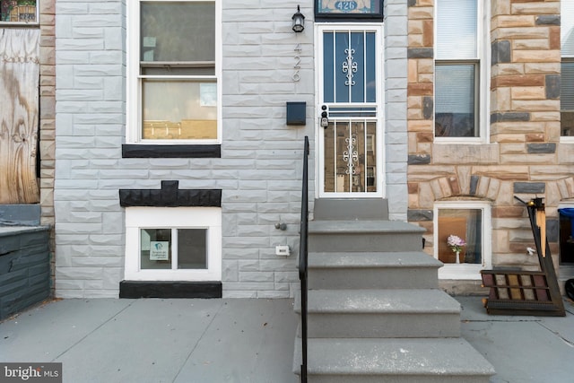 property entrance featuring stone siding