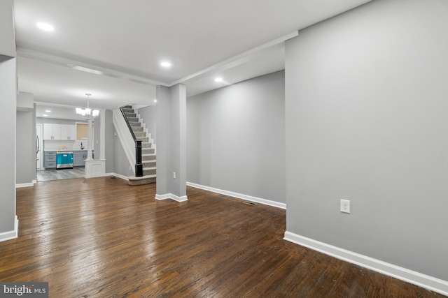 basement featuring baseboards, stairway, recessed lighting, dark wood-style floors, and a notable chandelier