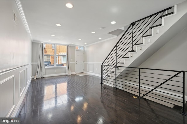 entrance foyer with crown molding and dark wood-type flooring