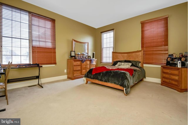 bedroom featuring light colored carpet and baseboards